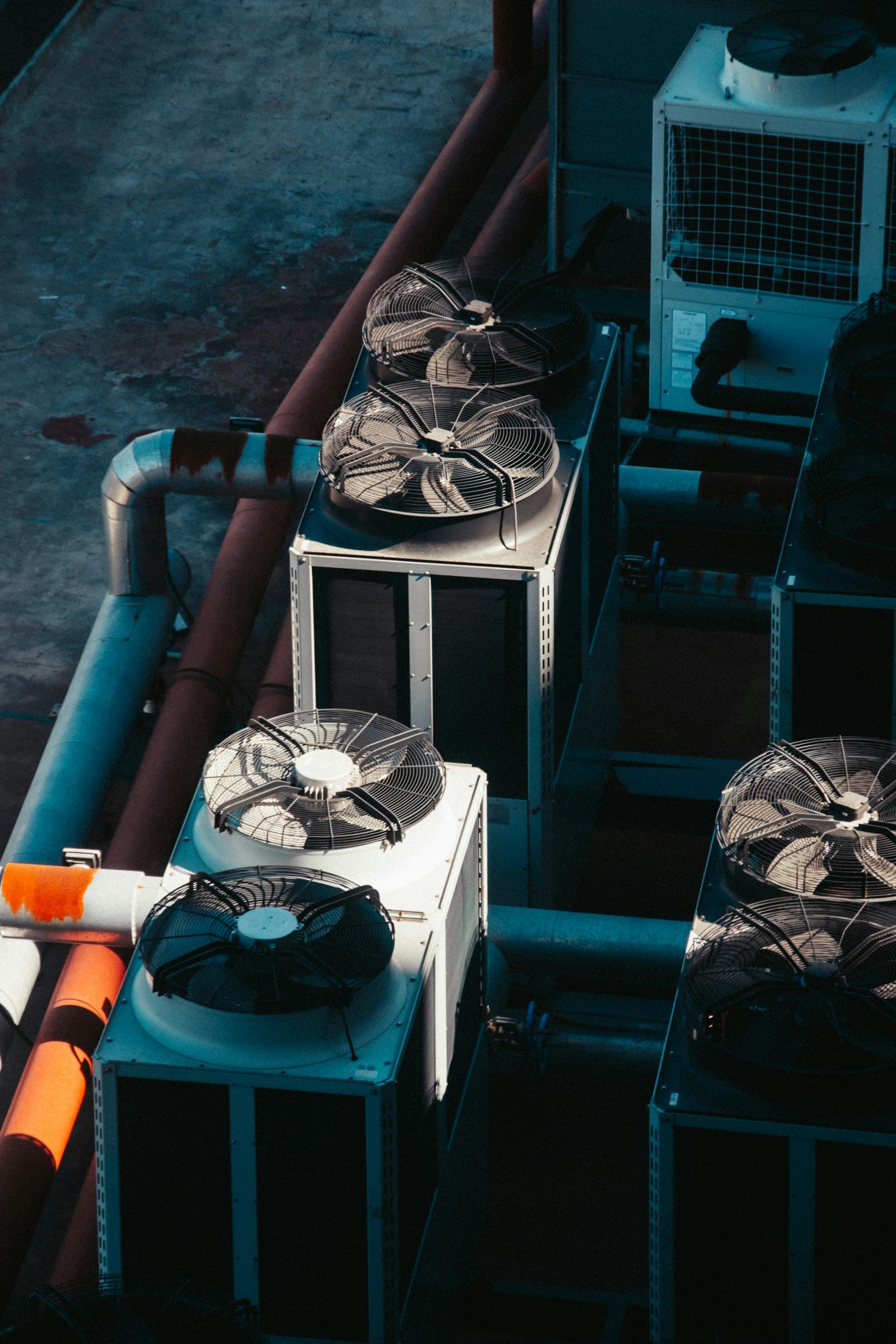 Groupes de froid industriels vus de dessus, ventilateurs et tuyauteries orange